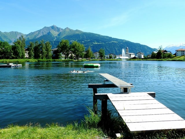 Bergsee mit Schwimmsteg vor blauem Himmel Bergsee mit Schwimmsteg vor blauem Himmel