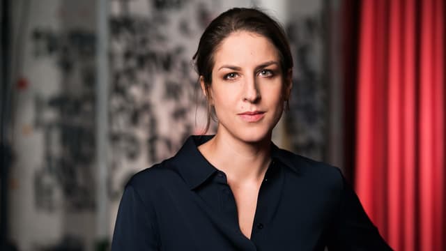 Eine junge, dunkelhaarige Frau mit einem schwarzen Oberteil. Eine junge, dunkelhaarige Frau mit einem schwarzen Oberteil.