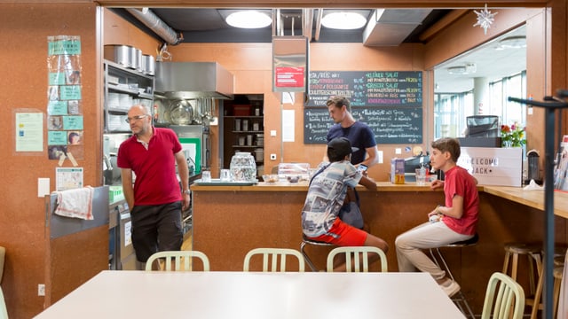 Zwei Jugendliche und zwei Helfer an der Bar des Jugendzentrums. Zwei Jugendliche und zwei Helfer an der Bar des Jugendzentrums.