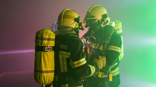 Zwei Feuerwehrleute mit Atomschutzanzügen Zwei Feuerwehrleute mit Atomschutzanzügen