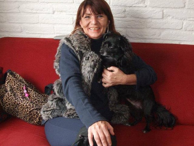 Frau mit Hund auf rotem Sofa Frau mit Hund auf rotem Sofa