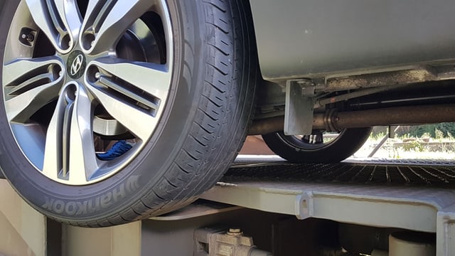 Nahaufnahme Autorad in der Luft neben Bahnwagen. Nahaufnahme Autorad in der Luft neben Bahnwagen.