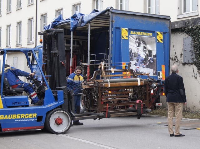 Gabelstapler mit Webstuhl vor Fabrik