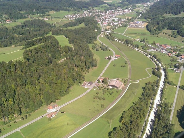 Durch das grüne Tösstal schlängelt sich ein heller Streifen, der mit grünen Bäumen gesäumt ist - die ausgetrocknete Töss. Durch das grüne Tösstal schlängelt sich ein heller Streifen, der mit grünen Bäumen gesäumt ist - die ausgetrocknete Töss.