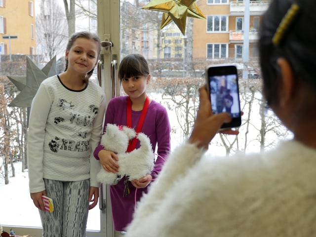 Ein Mädchen macht ein mit dem Smartphone ein Bild von zwei Freundinnen. Ein Mädchen macht ein mit dem Smartphone ein Bild von zwei Freundinnen.