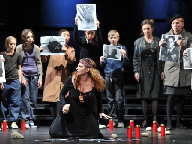 Mezzosopranistin Sanja Anastasia als Wahrsagerin Ulrica kauert vor dem Chor im Theater Basel. Mezzosopranistin Sanja Anastasia als Wahrsagerin Ulrica kauert vor dem Chor im Theater Basel.