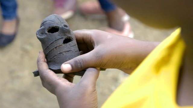 ein Kind hält eine Tonfigur ein Kind hält eine Tonfigur