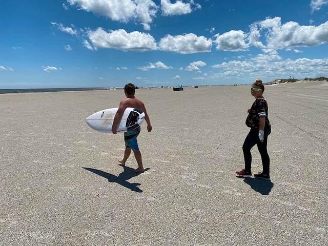 Ein Mann mit einem Surfboard am Strand. Ein Mann mit einem Surfboard am Strand.