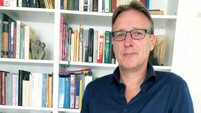 Mann vor Bücherwand Mann vor Bücherwand
