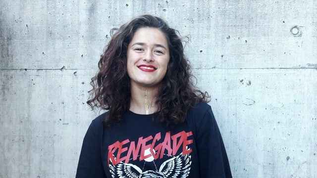 Eine junge Frau vor einer Betonwand. Eine junge Frau vor einer Betonwand.