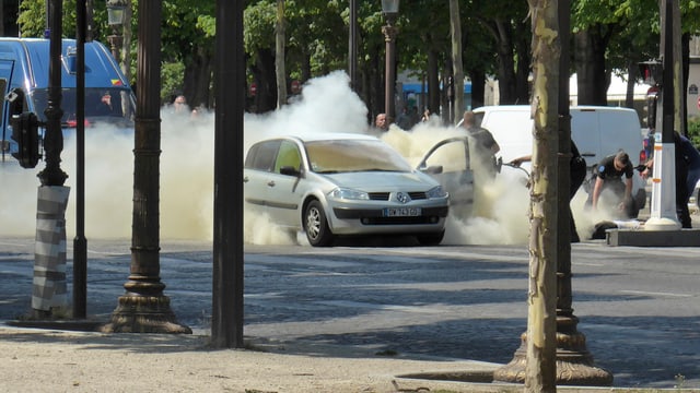 Feuerwehrleute löschen ein brennendes Auto. Feuerwehrleute löschen ein brennendes Auto.