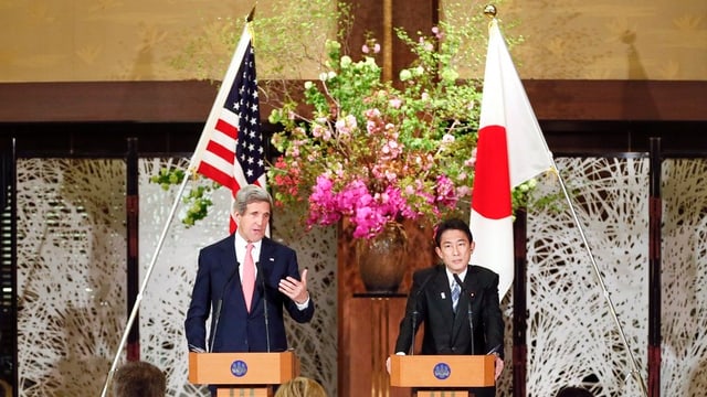 Kerry und Kishida an einem Rednerpult. Kerry und Kishida an einem Rednerpult.