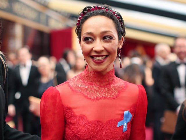 Schauspielerin Ruth Negga im roten Kleid und mit blauer Schleife. Schauspielerin Ruth Negga im roten Kleid und mit blauer Schleife.