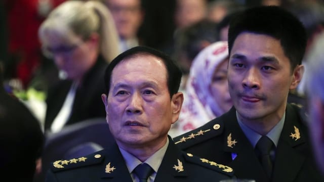 Der chinesische Verteidigungsminister Wei Fenghe mit einem Übersetzer. Der chinesische Verteidigungsminister Wei Fenghe mit einem Übersetzer.