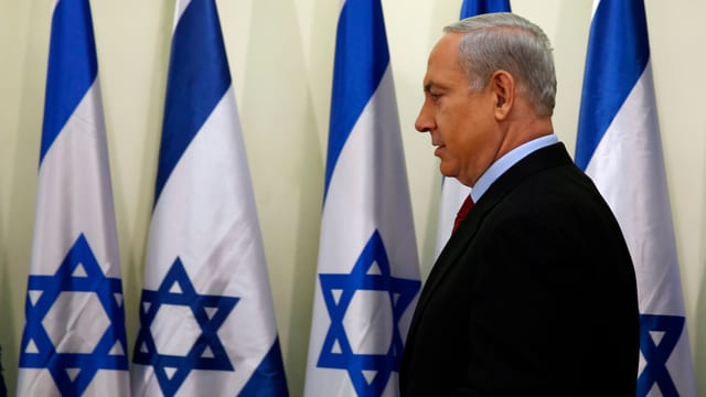 Benjamin Netanjahu geht mehreren Israel-Flaggen entlang. Benjamin Netanjahu geht mehreren Israel-Flaggen entlang.