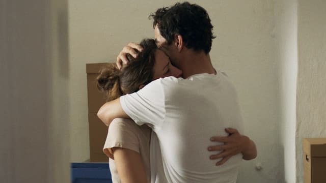 Eine Frau und ein Mann umarmen sich in einer leeren Wohnung. Eine Frau und ein Mann umarmen sich in einer leeren Wohnung.
