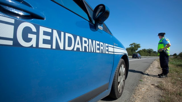 Polizeikontrolle der französischen Polizei mit einem Einsatzfahrzeug und einem Polizisten Polizeikontrolle der französischen Polizei mit einem Einsatzfahrzeug und einem Polizisten