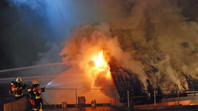 Feuerwehrleute löschen einen Brand eines Einfamilienhauses Feuerwehrleute löschen einen Brand eines Einfamilienhauses
