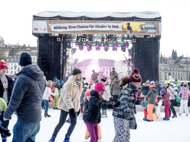 Vorne das Eisfeld, hinten das Konzert von Marius & die Jagdkapelle auf der «Jeder Rappen zählt»-Bühne.