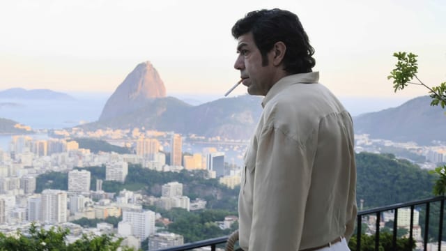 Ein Mann raucht eine Zigarette, im Hintergrund erkennt man Rio. Ein Mann raucht eine Zigarette, im Hintergrund erkennt man Rio.