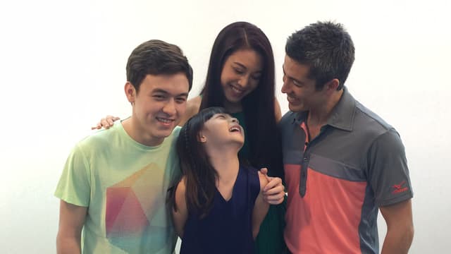 Ein Mann, eine Frau, ein Junge und ein Mädchen mit asiatischem Aussehen lächeln sich gegenseitig an. Ein Mann, eine Frau, ein Junge und ein Mädchen mit asiatischem Aussehen lächeln sich gegenseitig an.