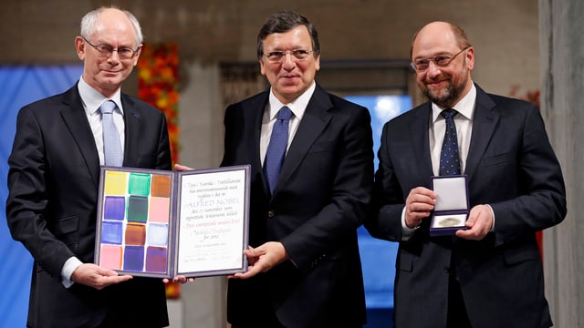 Die drei Männer mit einer Urkunde und einer Medaille in den Händen. Die drei Männer mit einer Urkunde und einer Medaille in den Händen.
