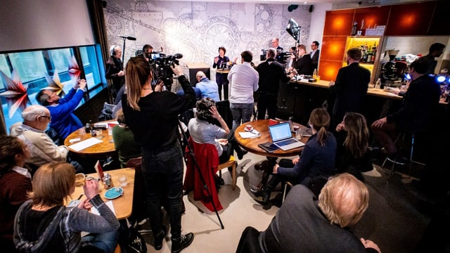 Cussegliera federala Doris Leuthard circumdada da schurnalistas e schurnalists en in'ustaria a Berna. Cussegliera federala Doris Leuthard circumdada da schurnalistas e schurnalists en in'ustaria a Berna.