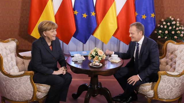 Merkel und Tusk sitzen an einem Tisch. Merkel und Tusk sitzen an einem Tisch.