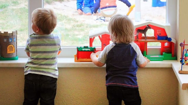 Zwei Kinder schauen aus dem Fenster Zwei Kinder schauen aus dem Fenster