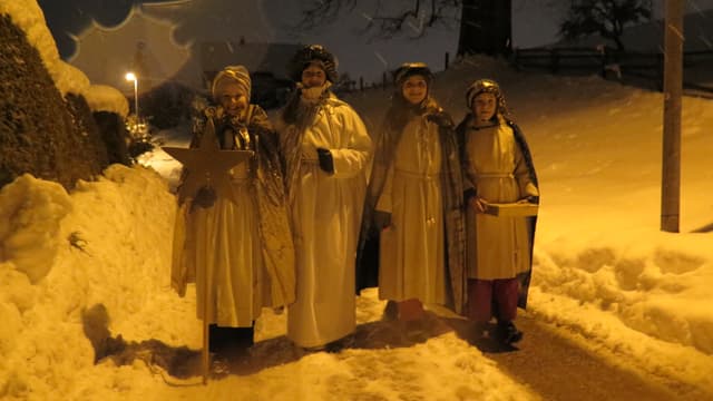 vier Sternsingerinnen stehen auf der verschneiten strasse vier Sternsingerinnen stehen auf der verschneiten strasse