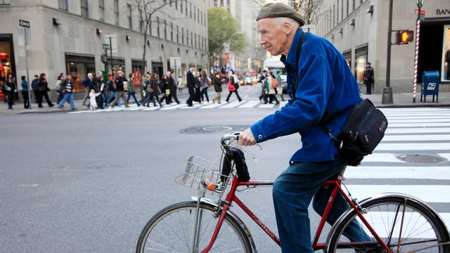 Cunningham mit blauer Jacke auf einem roten Velo. Cunningham mit blauer Jacke auf einem roten Velo.