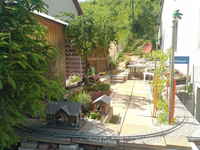 Eine Modelleisenbahn in einem Garten.