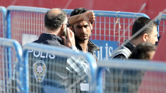 Die türkische Polizei nimmt einen illegal auf Griechenland gereisten Migrant in Empfang, der in die Kamera schaut und den Daumen senkt. Die türkische Polizei nimmt einen illegal auf Griechenland gereisten Migrant in Empfang, der in die Kamera schaut und den Daumen senkt.