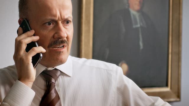 Ein glatzköpfiger Mann im Hemd telefoniert. Ein glatzköpfiger Mann im Hemd telefoniert.