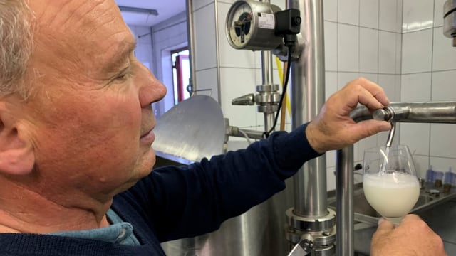 Christian Herzog füllt ein Glas unfiltrierten Wein in ein Glas ab. Christian Herzog füllt ein Glas unfiltrierten Wein in ein Glas ab.