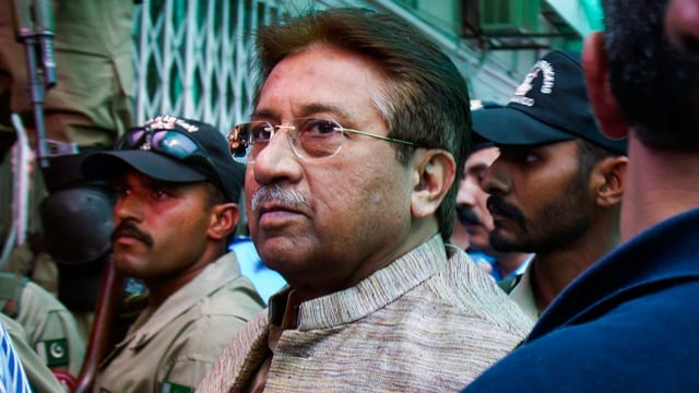Musharraf in Mitten von Polizeikräften. Musharraf in Mitten von Polizeikräften.