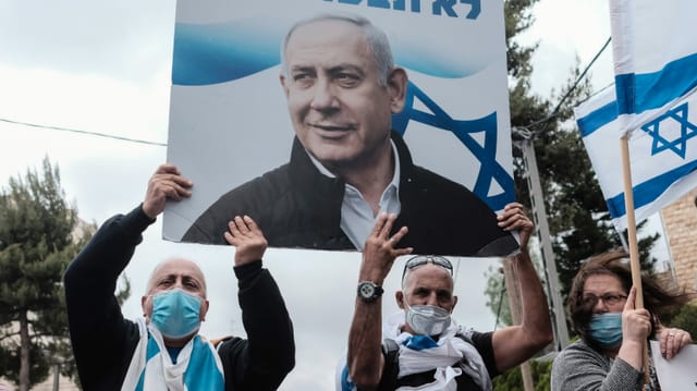 Protestierende, die ein Plakat von Netanjahu in den Händen halten. Protestierende, die ein Plakat von Netanjahu in den Händen halten.