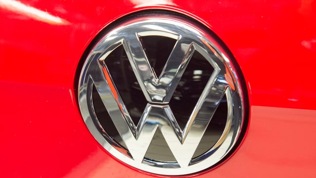 WV-Markenlogo an einem roten Auto WV-Markenlogo an einem roten Auto
