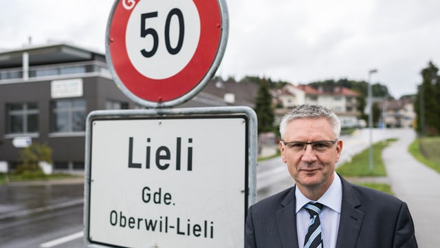 Andreas Glarner steht neben dem Ortsschild von Oberwil-Lieli