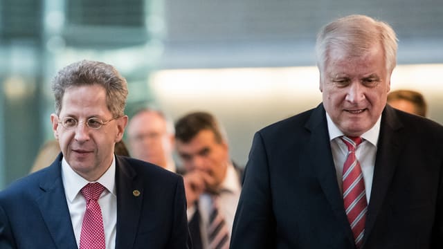 Zwei Männer stehen nebeneinander und schauen sich nicht an. Zwei Männer stehen nebeneinander und schauen sich nicht an.