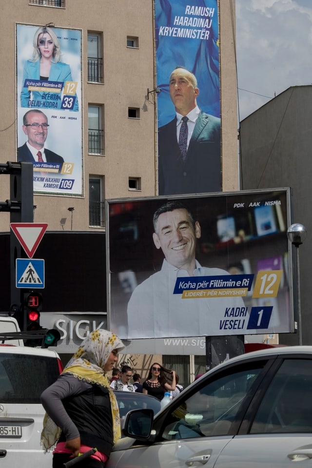 Eine Frau mit Kopftuch an einem Auto, im Hintergrund Wahlplakate. Eine Frau mit Kopftuch an einem Auto, im Hintergrund Wahlplakate.