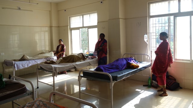 Neben jedem Bett auf Frauenstation des psychiatrischen Krankenhauses steht eine Angehörige, die nachts auf dem Boden schläft Neben jedem Bett auf Frauenstation des psychiatrischen Krankenhauses steht eine Angehörige, die nachts auf dem Boden schläft