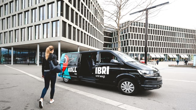 Schwarz-blauer Minivan vor Hochhäuser. Schwarz-blauer Minivan vor Hochhäuser.