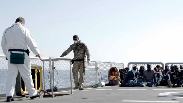 Flüchtlinge sitzen auf einem Boot. Flüchtlinge sitzen auf einem Boot.
