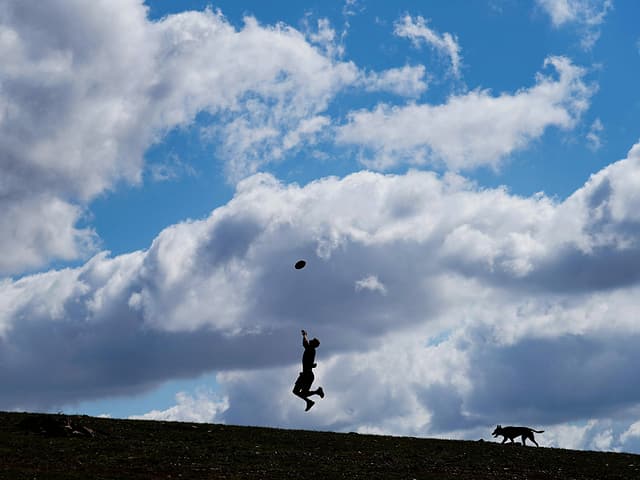 Ein Fussballer trainiert allein mit seinem Hund.