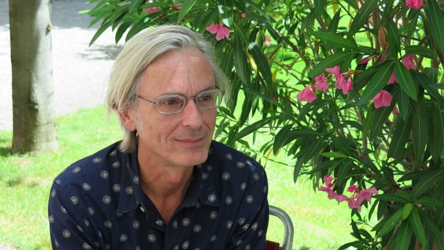 Mann mit grauen Haaren und Brillen vor Oleanderbusch. Mann mit grauen Haaren und Brillen vor Oleanderbusch.