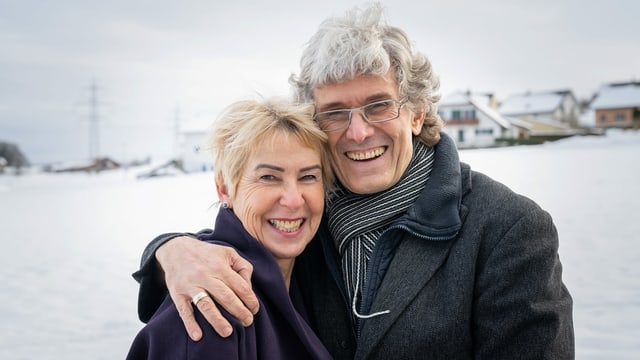 ein Mann lacht und umarmt seine Frau, die neben ihm steht ein Mann lacht und umarmt seine Frau, die neben ihm steht