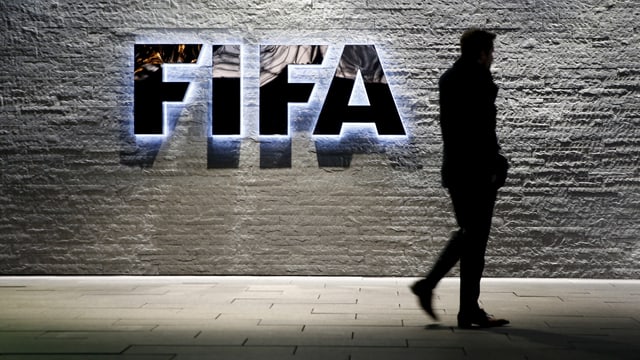 Fifa-Schriftzug am Gebäude des Hauptsitzes in Zürich mit einem schemenhaften Mann davor Fifa-Schriftzug am Gebäude des Hauptsitzes in Zürich mit einem schemenhaften Mann davor