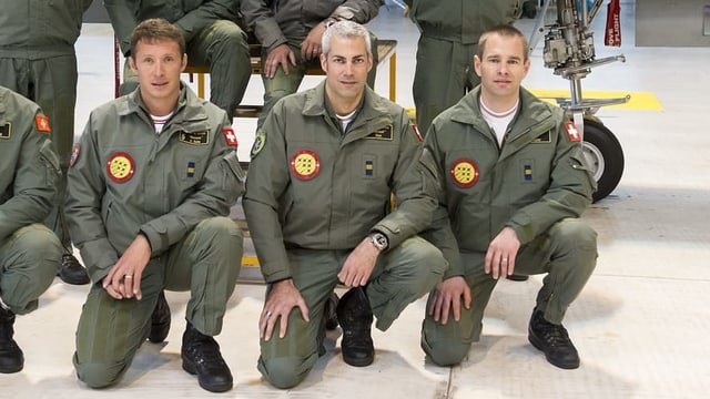 Man sieht drei Militärpiloten kniend. In der Mitte der grauhaarige Gunnar Jansen. Man sieht drei Militärpiloten kniend. In der Mitte der grauhaarige Gunnar Jansen.