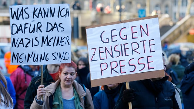 Demonstranten halten Plakate hoch Demonstranten halten Plakate hoch